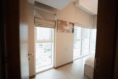 a room with large windows and a bed in it at Stylish and Charming 1BR in Urban Oasis by Missoni in Dubai