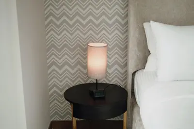 a lamp on a table next to a bed at Stylish and Charming 1BR in Urban Oasis by Missoni in Dubai