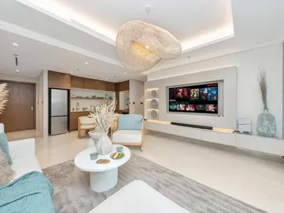 a living room with a couch and a tv at Palm and Marina Views in NEW Palace Beach Residence in Dubai
