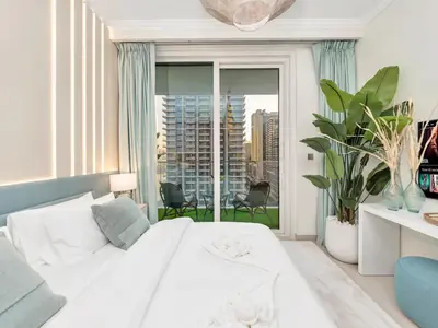 a bedroom with a white bed and a large window at Palm and Marina Views in NEW Palace Beach Residence in Dubai