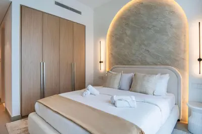a bedroom with a large bed with two towels on it at NEW 2 Bed w Rooftop Pool Panoramic Dubai Views in Dubai