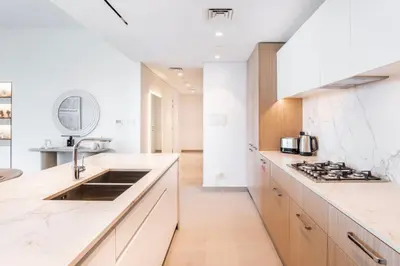 a kitchen with white marble countertops and a sink at NEW 2 Bed w Rooftop Pool Panoramic Dubai Views in Dubai