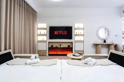 two beds in a room with a tv and a fireplace at NEW 2 Bed w Rooftop Pool Panoramic Dubai Views in Dubai