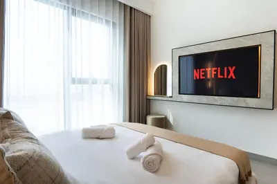 a bedroom with a bed with a television on the wall at NEW 2 Bed w Rooftop Pool Panoramic Dubai Views in Dubai