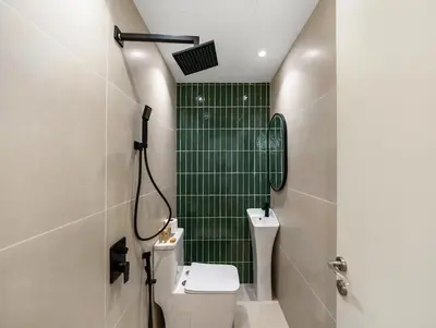 a bathroom with a toilet and a green tile shower at Luxury 2BR Apartment in Dubai Marina with Full Marina View in Dubai