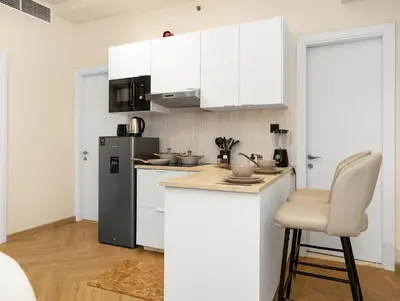 a kitchen with white cabinets and a white chair at Luxury 2BR Apartment in Dubai Marina with Full Marina View in Dubai