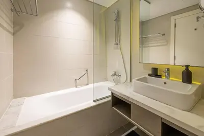 a white bathroom with a sink and a tub and a sink at BLVD - Stunning Canal View - 5 Minutes from Burj Khalifa in Dubai