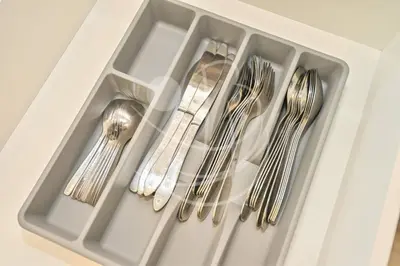 four silver utensils in a white drawer at Modern Cozy 1BR Retreat Azizi Riviera Dubai in Dubai