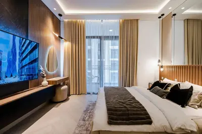 a bedroom with a large bed and a flat screen tv at Luxury Upgraded Studio in Wilton Park Residences in Dubai