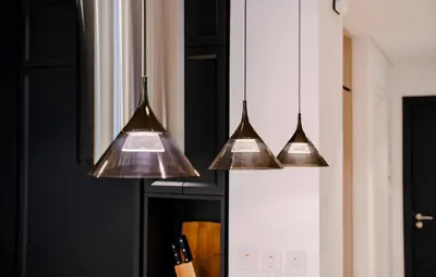 four copper pendant lights hanging over a kitchen counter at Luxury Upgraded Studio in Wilton Park Residences in Dubai