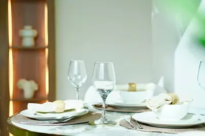 a table with plates and wine glasses on it at Private jacuzzi Canal View Infinity Pool in Dubai