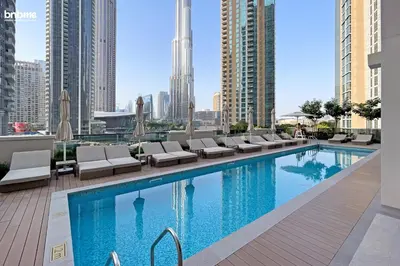 a swimming pool with lounge chairs and a city skyline at bnbmehomes - Act One Tower in Dubai