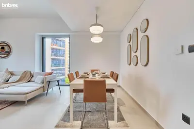 a dining room with a table and chairs and a couch at bnbmehomes - Act One Tower in Dubai
