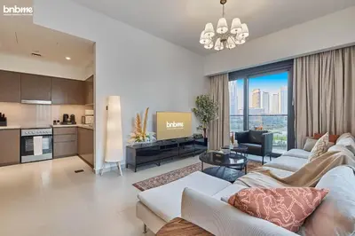 a living room with a couch and a kitchen at bnbmehomes - Act One Tower in Dubai