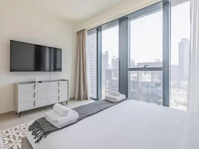 a white bedroom with a large bed and large windows at TRPS - BLVD Heights, Downtown Dubai - Luxury 1BR, Close to Dubai Mall in Dubai