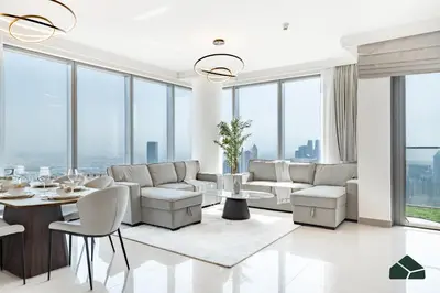 a living room with white furniture and large windows at High Floor 2BR with Full Burj View by BMS in Dubai