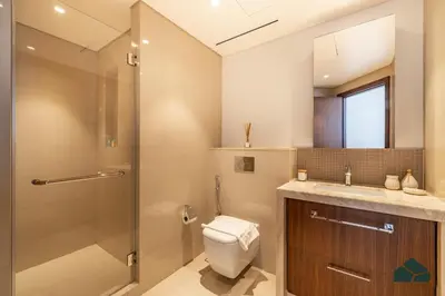 a bathroom with a shower and a toilet and a sink at High Floor 2BR with Full Burj View by BMS in Dubai
