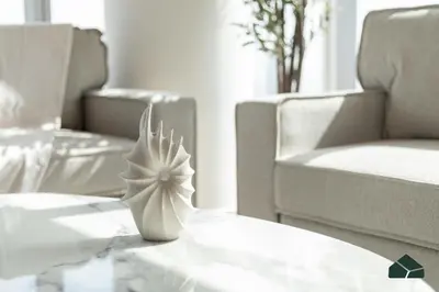 a white flower vase sitting on a table with chairs at High Floor 2BR with Full Burj View by BMS in Dubai