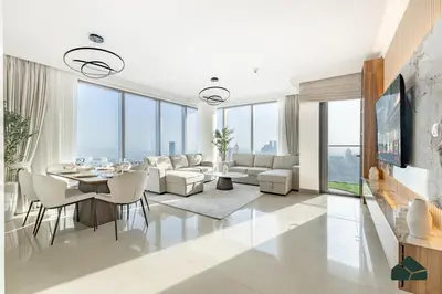 a living room with white furniture and glass windows at High Floor 2BR with Full Burj View by BMS in Dubai