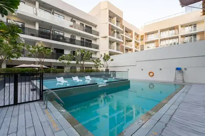 a swimming pool in front of a building at Lux & New 2 BHK in Jumeirah Village Circle I Close to everything I Pool I High Speed Internet I Balcony in Dubai