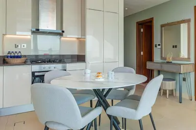 a kitchen with a white table and chairs at Vacay Lettings - Marina Gate 2 in Sabkhah