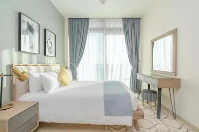 a bedroom with a bed and a desk and a window at Vacay Lettings - Marina Gate 2 in Sabkhah