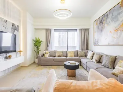 a living room with a couch and a tv at TRPS - Act One Act Two Towers, Downtown Dubai - 3BR Plus Maid with Iconic Burj Khalifa View in Dubai