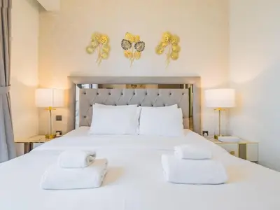 a bedroom with a large white bed with butterflies on the wall at TRPS - Act One Act Two Towers, Downtown Dubai - 3BR Plus Maid with Iconic Burj Khalifa View in Dubai