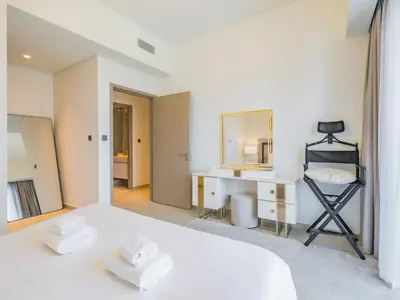a white bedroom with a bed and a mirror at TRPS - Act One Act Two Towers, Downtown Dubai - 3BR Plus Maid with Iconic Burj Khalifa View in Dubai
