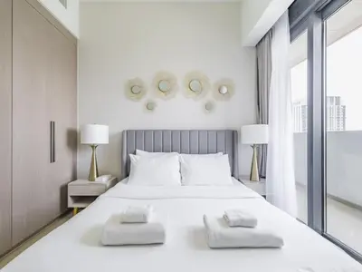 a white bedroom with a large white bed with two pillows at TRPS - Act One Act Two Towers, Downtown Dubai - 3BR Plus Maid with Iconic Burj Khalifa View in Dubai