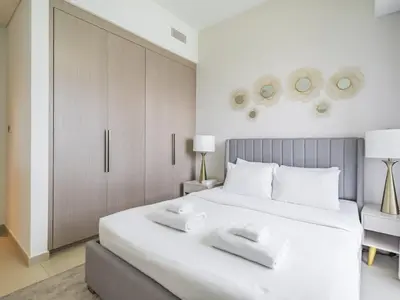 a bedroom with a large white bed with two white towels at TRPS - Act One Act Two Towers, Downtown Dubai - 3BR Plus Maid with Iconic Burj Khalifa View in Dubai