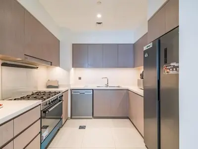 a kitchen with a stove and a refrigerator at TRPS - Act One Act Two Towers, Downtown Dubai - 3BR Plus Maid with Iconic Burj Khalifa View in Dubai