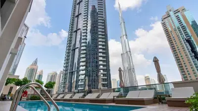a view of a tall building with a swimming pool at TRPS - Act One Act Two Towers, Downtown Dubai - 3BR Plus Maid with Iconic Burj Khalifa View in Dubai