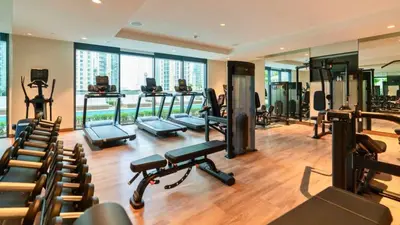 a gym with several treadmills and exercise equipment in a building at TRPS - Act One Act Two Towers, Downtown Dubai - 3BR Plus Maid with Iconic Burj Khalifa View in Dubai