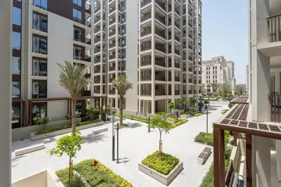 an apartment courtyard with palm trees and buildings at GuestReady - Tasteful home in Dubai Creek Harbour in Dubai