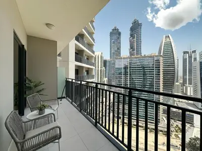 a balcony with two chairs and a view of the city at Chic 1BR in Business Bay City Views & Upscale Comfort in Dubai