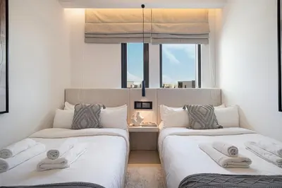 two beds in a room with a window at Elegant 4BR Villa, Luxury Pool Retreat, Joy, Arabiana Ranches 3 in Sabkhah