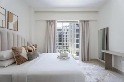 a white bedroom with a large bed with a window at GuestReady - Stylish Stay with Dubai Skyline Views in Dubai