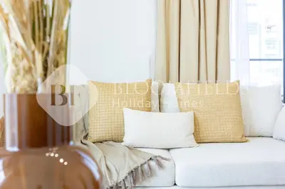 a white couch with pillows in a living room at Bloomfields Cozy 1BR Binghatti Nova in Dubai