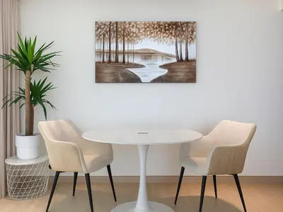 a table and chairs in a room with a painting at Big 1BR Apartment in JVC Binghatti Corners in Dubai
