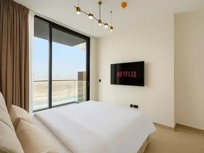 a bedroom with a white bed and a large window at Big 1BR Apartment in JVC Binghatti Corners in Dubai
