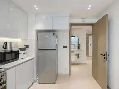 a kitchen with white cabinets and a refrigerator at Big 1BR Apartment in JVC Binghatti Corners in Dubai