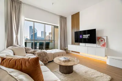a living room with a couch and a tv at New! 1BR with Balcony Views and Pool by Burj Khalifa in Dubai