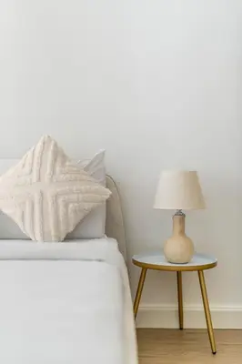a bed with a lamp on a side table at New! 1BR with Balcony Views and Pool by Burj Khalifa in Dubai