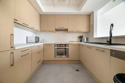an empty kitchen with white cabinets and appliances at New! 1BR with Balcony Views and Pool by Burj Khalifa in Dubai