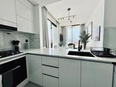 a kitchen with white cabinets and a sink at Sun Deck & Sleek Lap Pool Free Gym And Parking! in Dubai
