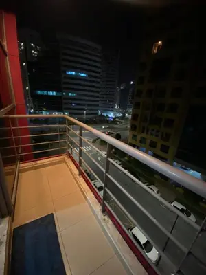 a view of a city at night from a balcony at Eden Retreat Partition room For Couple In Barsha Heights in Dubai