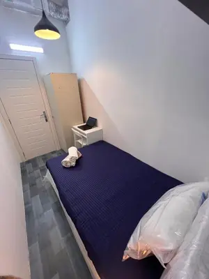 a bedroom with a blue bed with a stuffed animal on it at Eden Retreat Partition room For Couple In Barsha Heights in Dubai