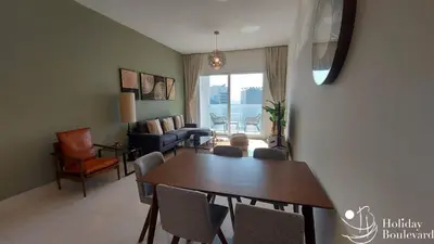 a living room with a dining room table and chairs at Stylish 1br Brand New Prime Business Bay Stay in Dubai