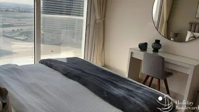 a bedroom with a bed and a desk and a mirror at Stylish 1br Brand New Prime Business Bay Stay in Dubai
